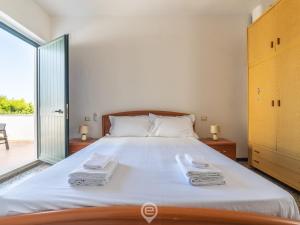 La Casa sul Mare في San Vero Milis: غرفة نوم بها سرير كبير مع مناشف عليه