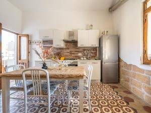 La Casa sul Mare في San Vero Milis: مطبخ مع طاولة مع كراسي وثلاجة +18 صورة