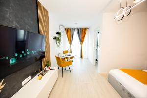ein Schlafzimmer mit einem großen Flachbildfernseher und einem Bett in der Unterkunft Metropolis Elegance in Bukarest