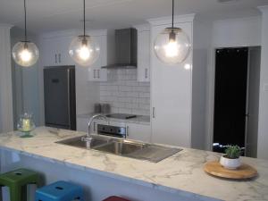 a kitchen with a sink and pendant lights at Seagulls in Lancelin