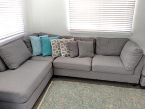 a gray couch with pillows in a living room at Seagulls in Lancelin