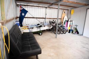 a garage with a boat and a couch in it at Seabliss in Lancelin +4 photos