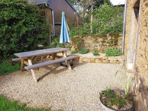 a picnic table and an umbrella in a garden at Chez Alex, La Grange in Saint-Brieuc-des-Iffs