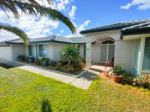 a house with a palm tree in the yard at Sea-renity Now in Lancelin