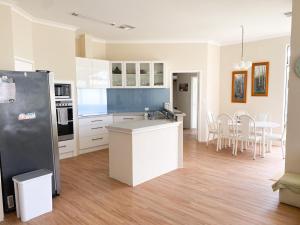a kitchen with a refrigerator and a table with chairs at Sea-renity Now in Lancelin