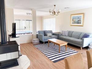 a living room with a couch and a table at Sea-renity Now in Lancelin