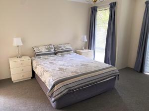 a bedroom with a large bed and two night stands at Sea-renity Now in Lancelin