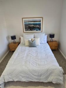 a bedroom with a large white bed with two night stands at Sou Wester in Lancelin