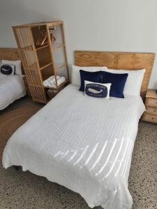 a bedroom with a large white bed with blue pillows at Sou Wester in Lancelin