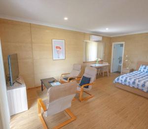 a bedroom with a bed and chairs and a table at Things of Stone and Wood in Lancelin