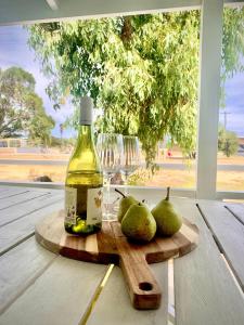 a bottle of vinegar and pears on a wooden cutting board at Playgrounds in Lancelin