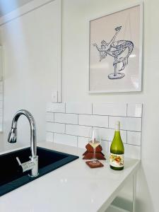 a kitchen counter with a sink and a wine glass at Playgrounds in Lancelin +8 photos