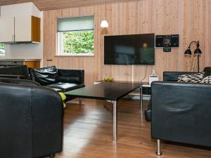 ein Wohnzimmer mit Tisch und Fernseher in der Unterkunft Luxury Retreat with Pool - By Traum Ferienwohnungen in Ebeltoft