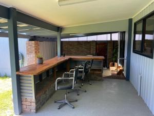 an outdoor patio with a wooden table and chairs at The Newby in Lancelin