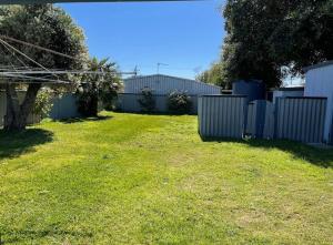 a backyard with a fence and a grass yard at The Newby in Lancelin