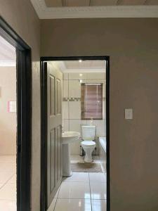 a bathroom with a white toilet and a sink at The Hope Apartments in Nelspruit