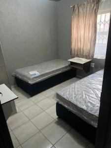a room with two beds and a window at The Hope Apartments in Nelspruit