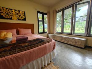 a bedroom with a large bed and windows at TheOrientalVillage in Ban Pao Sam Kha +56 photos