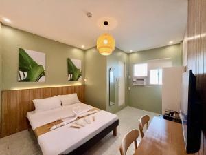 a bedroom with a bed and a table and a tv at ABC Homes PH in Olongapo