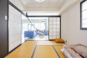 una habitación con una cama y un columpio en Onjjukuオーシャンビューコンドミニアム最上階角部屋, en Onjuku