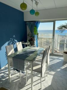 una mesa de comedor y sillas con vistas al océano en Onjjukuオーシャンビューコンドミニアム最上階角部屋, en Onjuku
