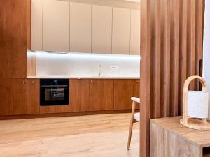 cocina con armarios de madera y capucha de acero inoxidable en Central Sunrise Mad Luxury Residence, en Cluj-Napoca 13 fotos más