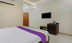 Un dormitorio con una cama y un televisor en la pared. en hari om guest house, en Baga