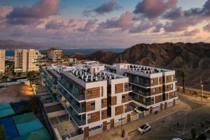 une vue aérienne sur un bâtiment avec des montagnes en arrière-plan dans l'établissement Red Canyon Spa Peaceful Stay by Sea N' Rent, à Eilat