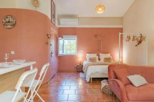 a bedroom with a bed and a table and a couch at Domaine Plan Des Devens Volupté in Roussillon +16 photos