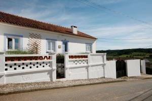 een wit huis met een wit hek ervoor bij Casa das Alfazemas in Cadaval