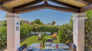 Una mesa de comedor bajo una pérgola en un jardín. en Casa Gio, en Tortolì