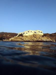 a building on an island in the water at Psili Ammos in Mylopotas