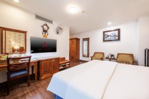 a bedroom with a bed and a desk and a tv at A25 Hotel - 19 Phan Đình Phùng in Hanoi
