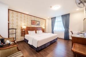a bedroom with a large white bed and a desk at A25 Hotel - 19 Phan Đình Phùng in Hanoi