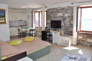 a bedroom with two beds and a kitchen with a tv at Apartments & Rooms Riva in Piran