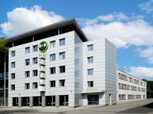 a white building with a sign on it at B&B HOTEL Bielefeld-City in Bielefeld