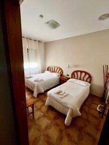 a room with two beds in a room at Hostal Castilla in Mocejón