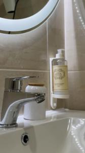 a bathroom sink with a soap dispenser and a mirror at Loreto Apartment in Bragança