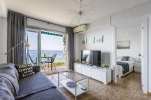 トレ・デル・マールにあるSea View & Beach View Appartement Torre Del Marのソファ、ベッド、テレビのあるリビングルーム