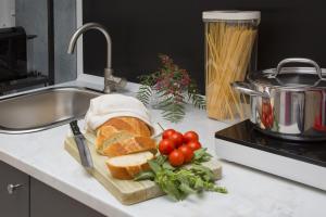 a sandwich and tomatoes on a cutting board on a kitchen counter at Donna Lucia by Armerina Sicily Apartments in Piazza Armerina