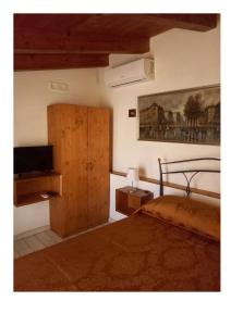 a bedroom with a bed and a dresser with a television at Gradem in Bitonto