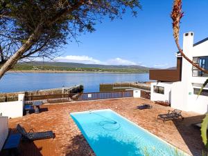 a swimming pool with a view of a lake at Witsand Holiday House in Witsand