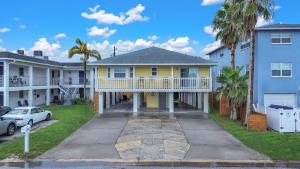 a yellow house with a balcony and a driveway at Beach Please in St Pete Beach