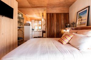 Un dormitorio con una gran cama blanca y una cocina. en Studio entre lac et foret, en Lacanau