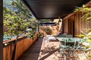 Una terraza de madera con una mesa y sillas. en Studio entre lac et foret, en Lacanau