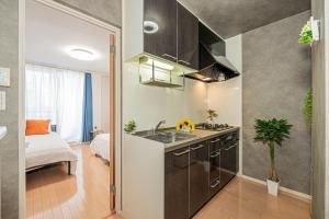 a kitchen with a sink and a bed in a room at 301 6 mins walk from Higashi-Jujo Station Comfortable 1 bedroom apartment on the 3rd floor Direct access to Akihabara and Ueno in Tokyo