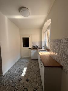 a kitchen with white cabinets and a tile floor at V&V La Vie Est Belle in Neuchâtel