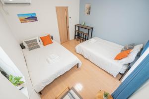 a bedroom with two beds and a table at 301 6 mins walk from Higashi-Jujo Station Comfortable 1 bedroom apartment on the 3rd floor Direct access to Akihabara and Ueno in Tokyo