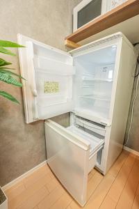 an empty refrigerator with its door open in a kitchen at 301 6 mins walk from Higashi-Jujo Station Comfortable 1 bedroom apartment on the 3rd floor Direct access to Akihabara and Ueno in Tokyo