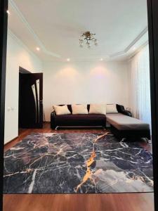 a living room with a couch and a rug at Международный Аэропорт Алматы Апартаменты "100 метров" in Almaty